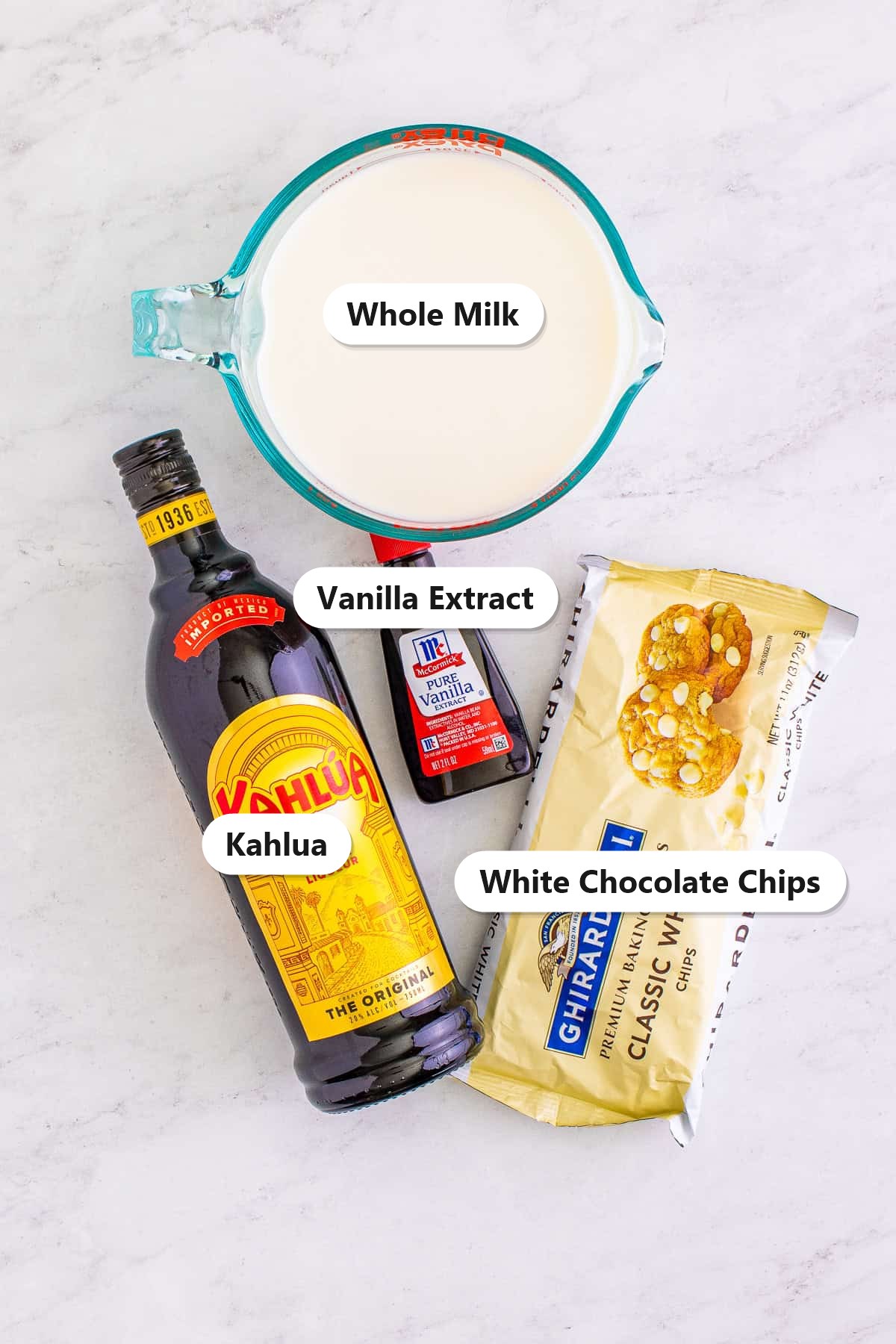 Labeled ingredients for kahlua hot chocolate including whole milk, white chocolate chips, Kahlua coffee liqueur, and vanilla extract.