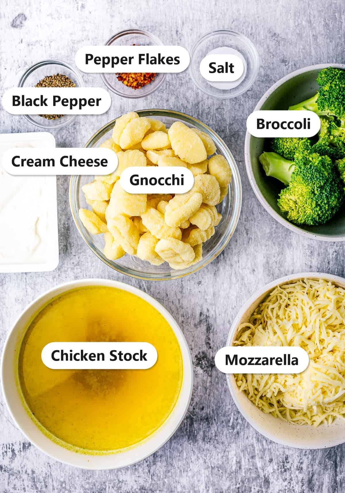 Labeled ingredients to make broccoli gnocchi including gnocchi, broccoli, chicken stock, cream cheese, mozzarella, and seasonings