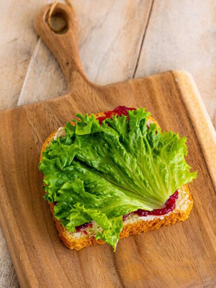 Green leaf lettuce layered over the cranberry sauce on the leftover turkey sandwich.