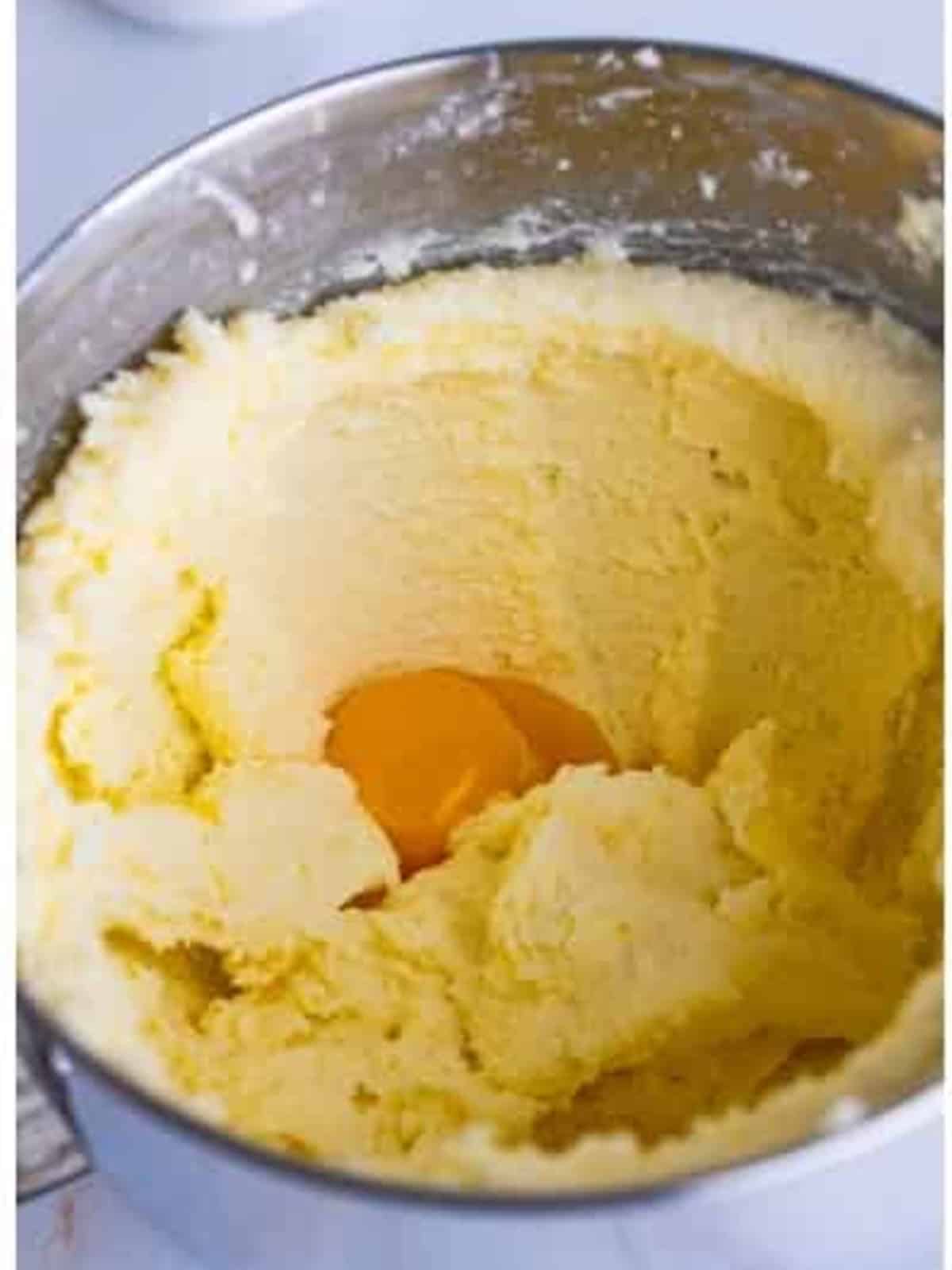 Beating egg yolks and whole eggs into the creamed butter and sugar for Lemon Blueberry Pound Cake.