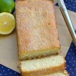 Glazed lemon lime cake on parchment with two slices cut showing the tender crumb.