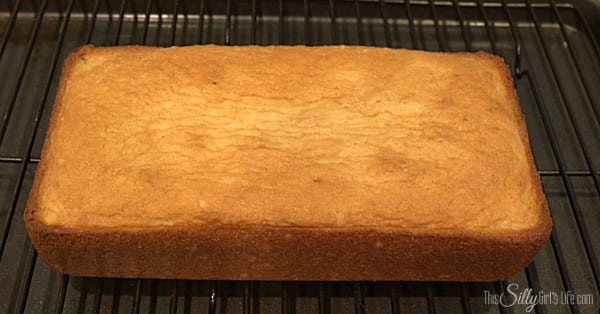 Golden baked lemon lime cake cooling on a wire rack.