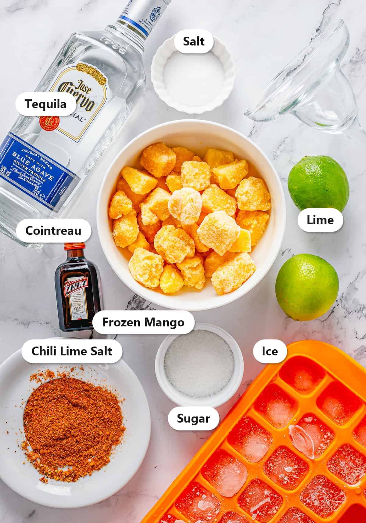 Labeled ingredients for mango margaritas including tequila, Cointreau, frozen mango, lime, sugar, salt, chili lime salt, and ice.