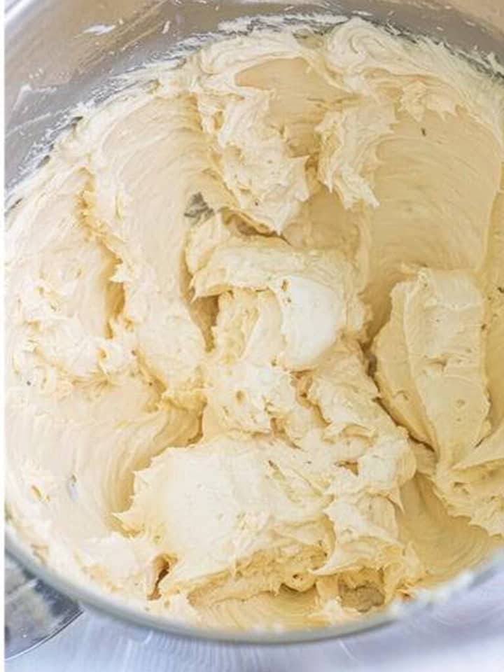 Maple syrup, vanilla, and salt stirred into the frosting base in the mixer bowl.