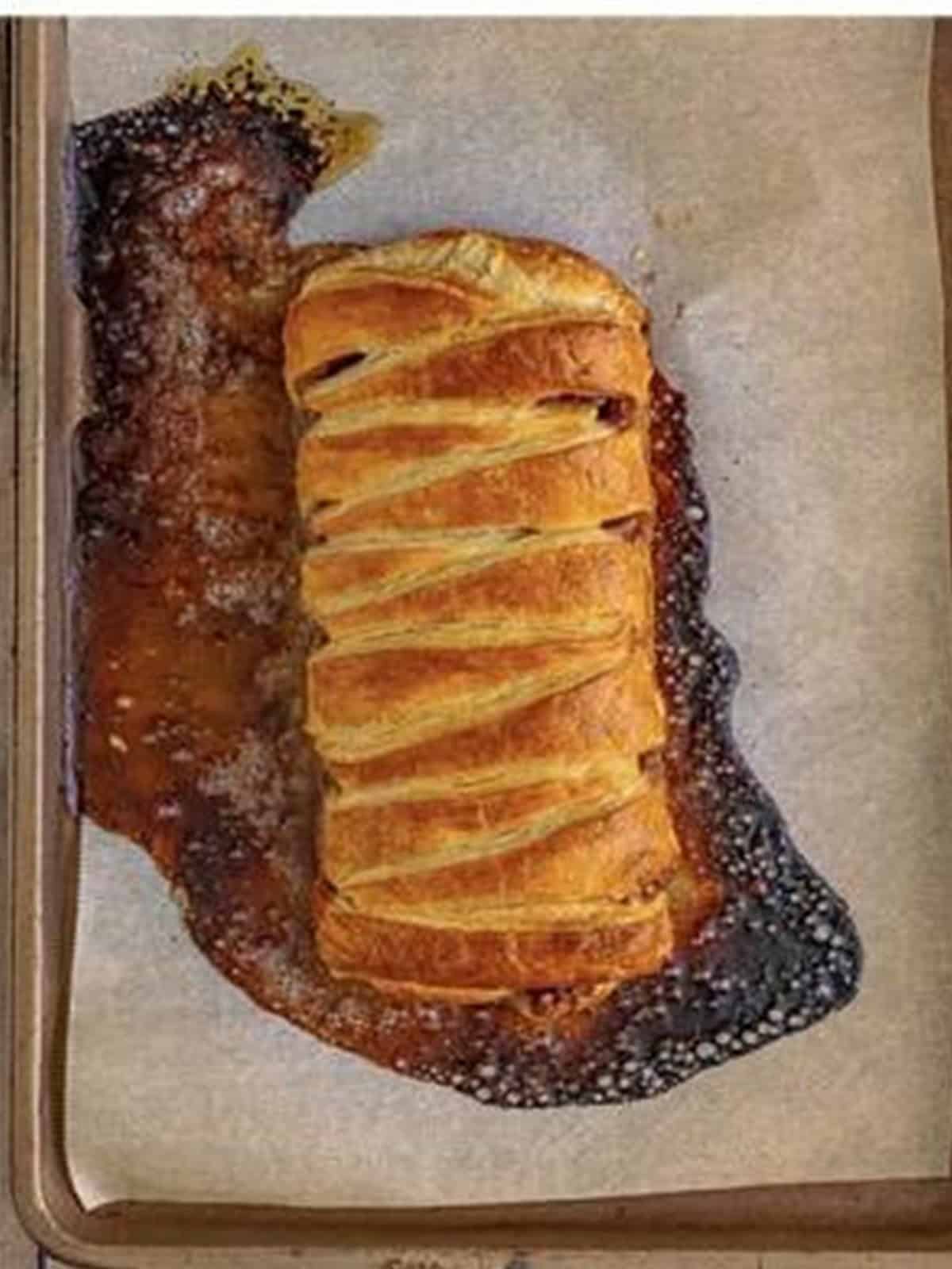 The golden baked Maple Pecan Pastry Braid fresh out of the oven on a sheet pan.