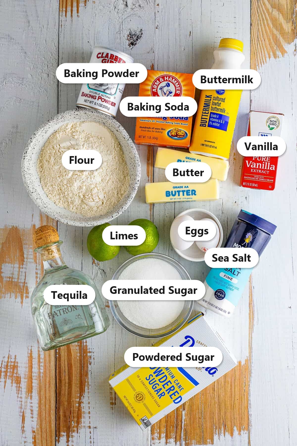 Labeled ingredients for margarita cupcakes including flour, butter, granulated sugar, eggs, limes, tequila, buttermilk, vanilla, baking powder, baking soda, sea salt, and powdered sugar.