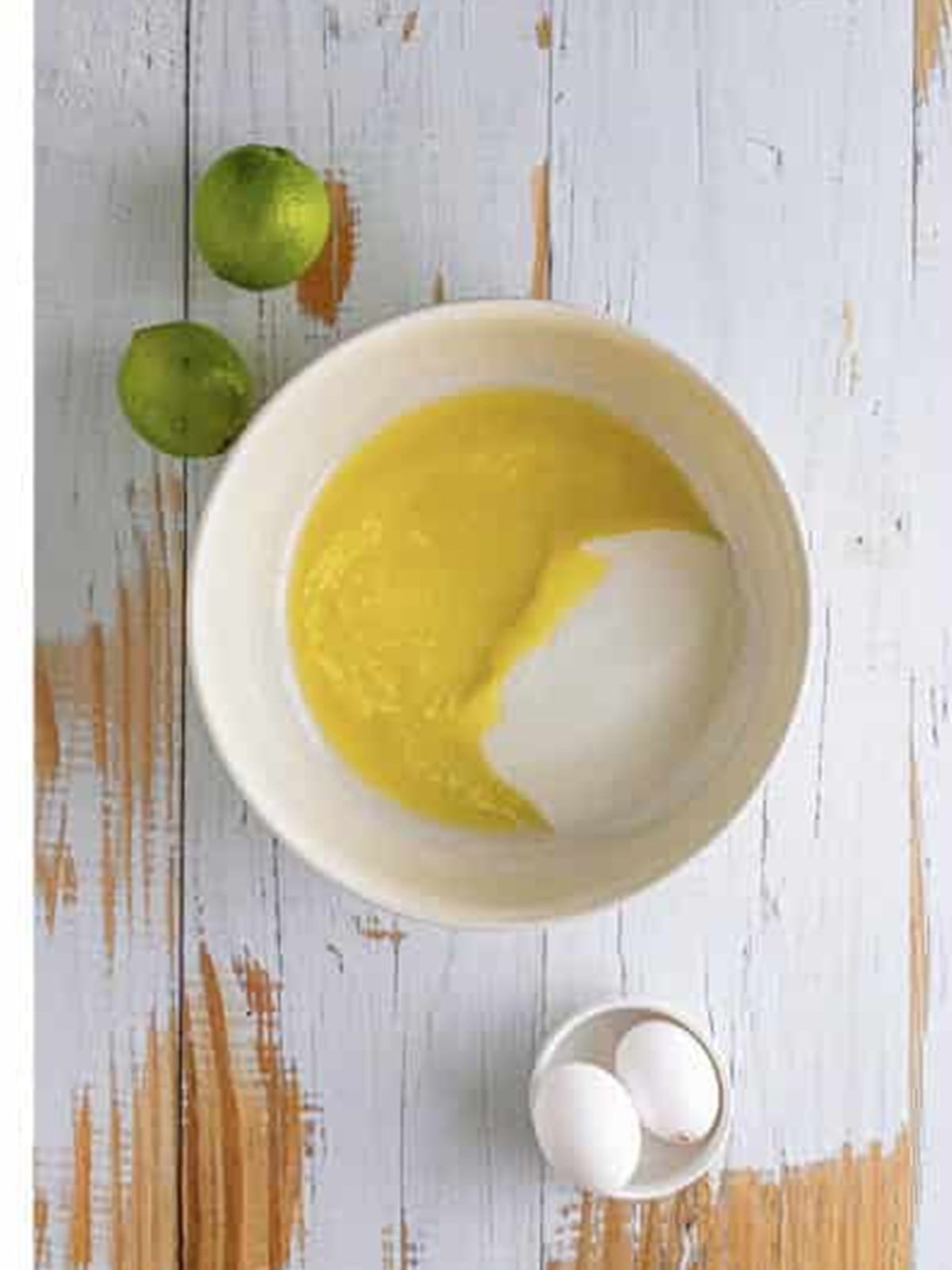 Melted butter and sugar whisked together in a mixing bowl for margarita cupcakes.