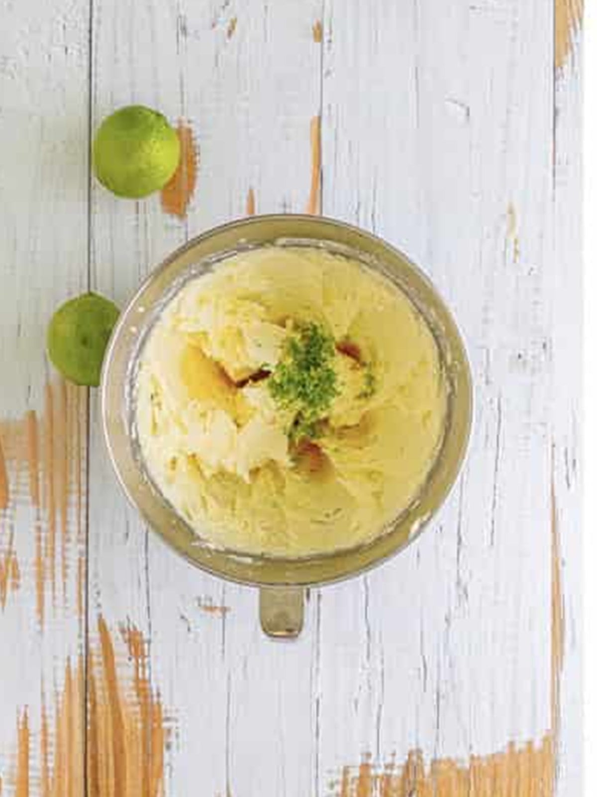 Adding tequila, vanilla, and lime zest to the whipped frosting.