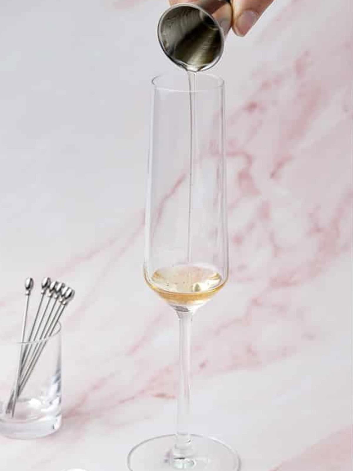 Watermelon syrup poured into a champagne flute for the Melon Cocktail.