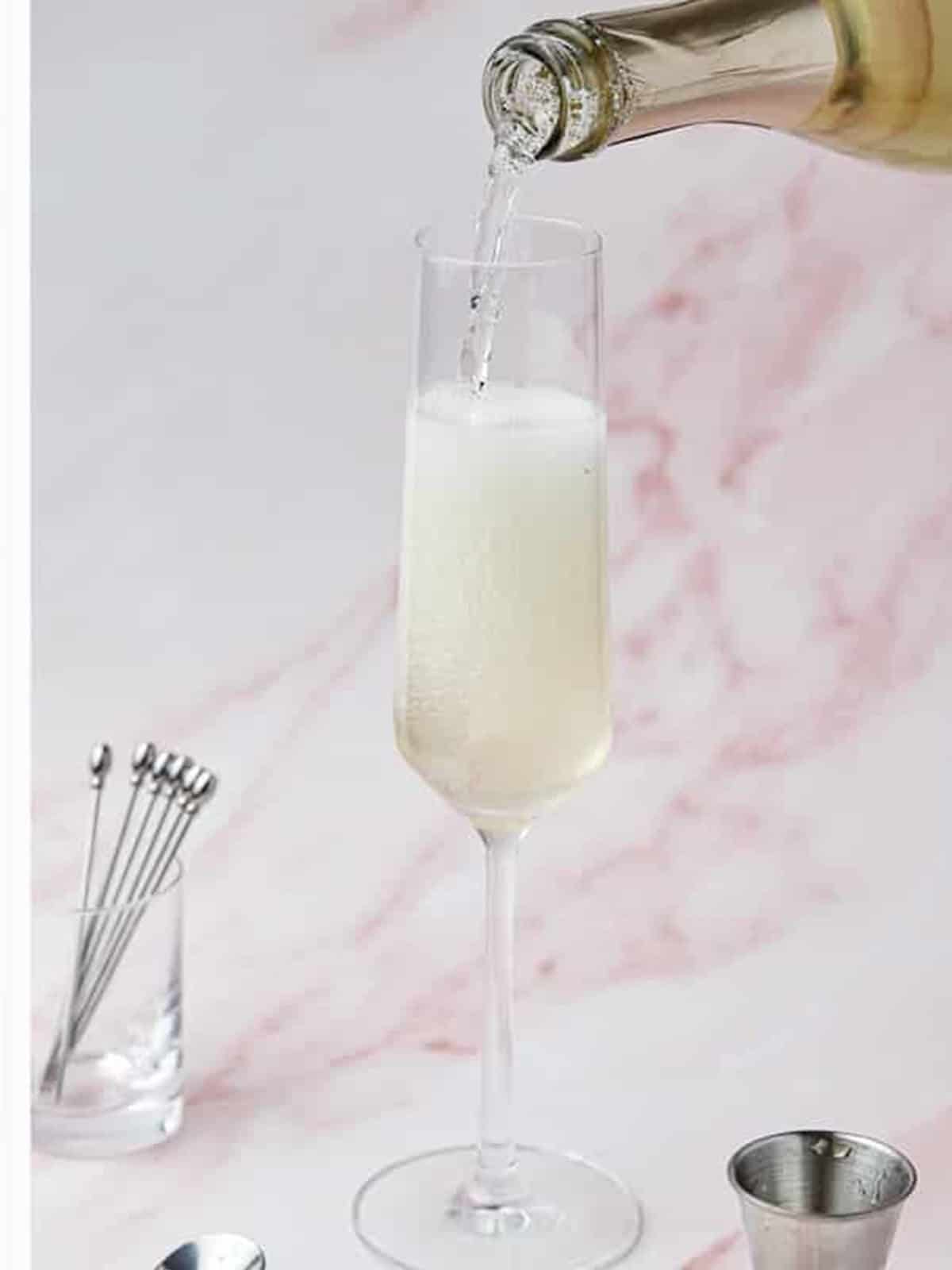 Prosecco topping the watermelon syrup in a champagne flute.
