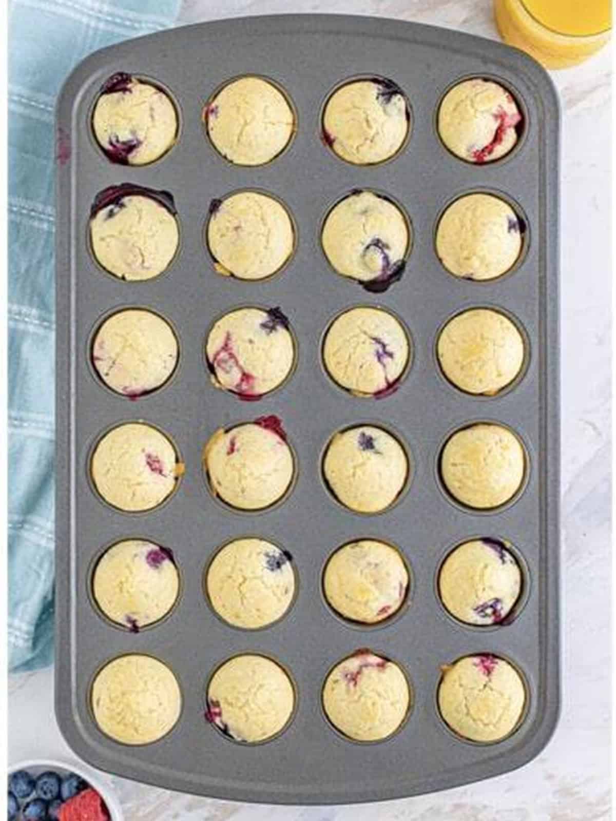 Berry pancake batter filled into a mini muffin tin ready to bake.