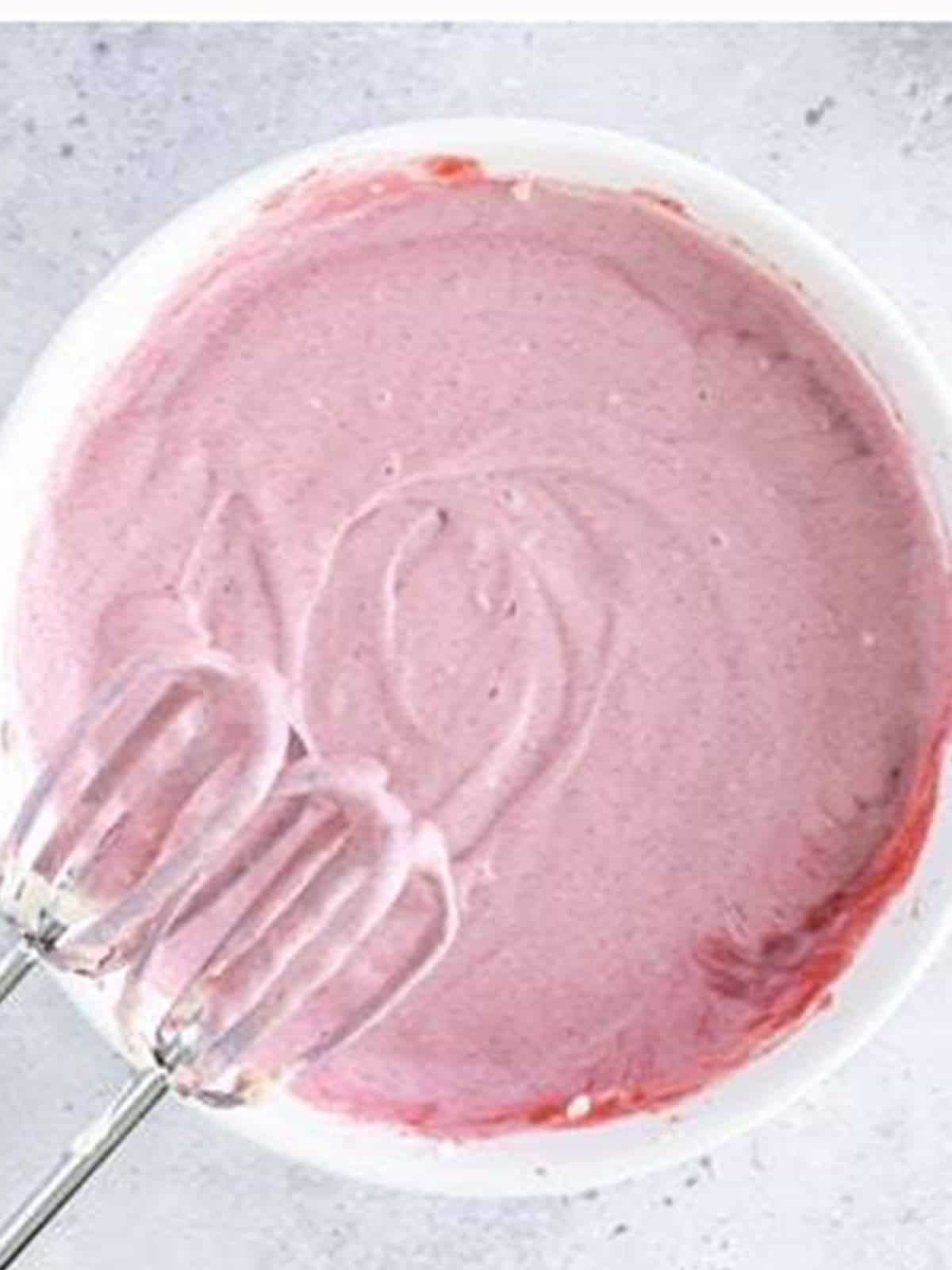 Raspberry puree mixed into the cheesecake filling turning it pink for mini lemon cheesecakes.
