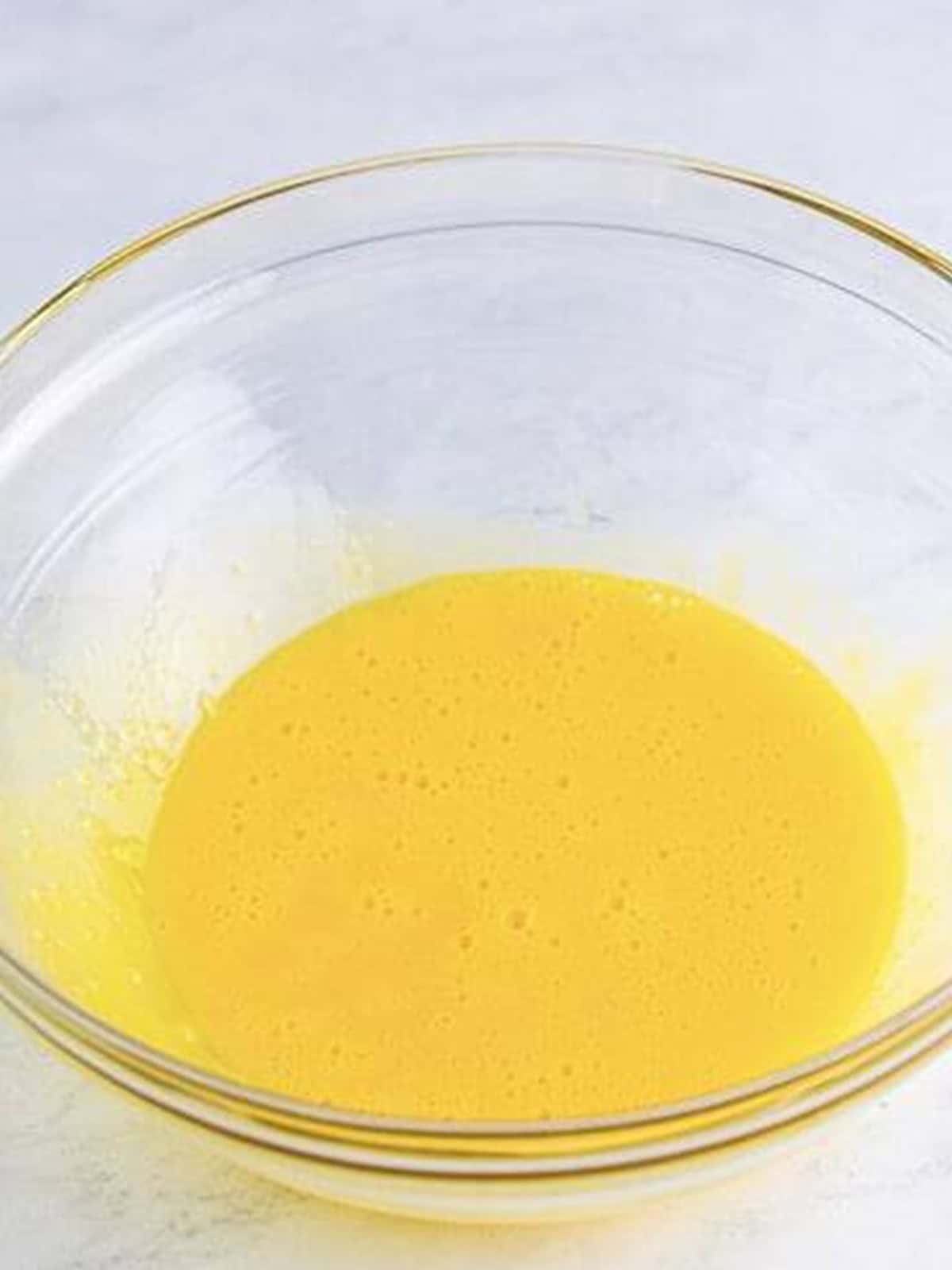 Egg yolks whisked smooth in a glass bowl for the creme brulee custard.