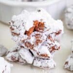 A pile of Muddy Buddy Cookies, chocolate peanut butter Chex clusters coated in powdered sugar.