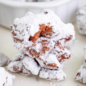 A pile of Muddy Buddy Cookies, chocolate peanut butter Chex clusters coated in powdered sugar.