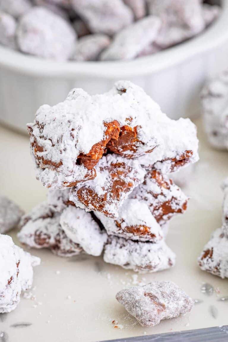 A pile of Muddy Buddy Cookies, chocolate peanut butter Chex clusters coated in powdered sugar.