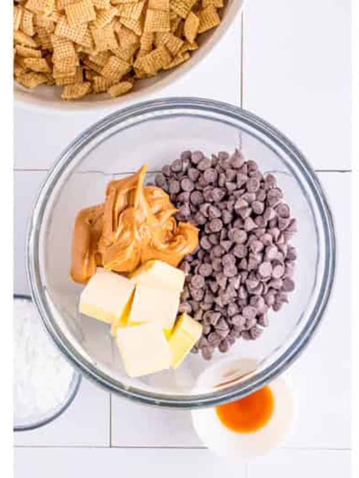 Chocolate chips, peanut butter, and butter added to a microwave-safe bowl for Muddy Buddy Cookies.