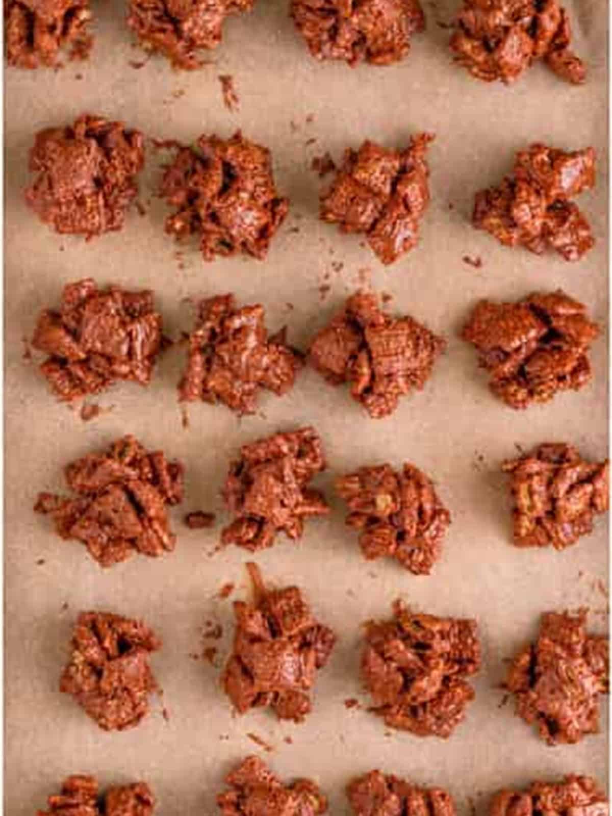 Scooping the coated cereal into cluster mounds on a parchment-lined tray to set.