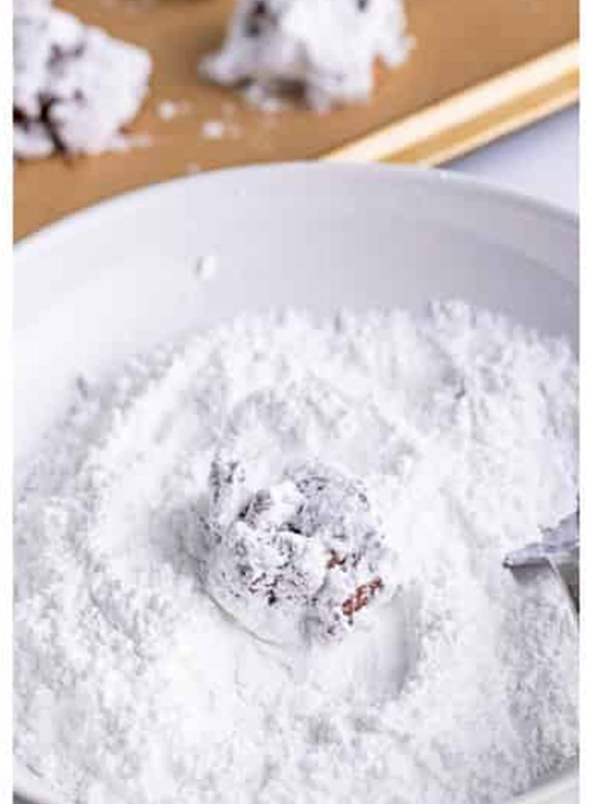 Coating the chilled cereal clusters in powdered sugar for Muddy Buddy Cookies.