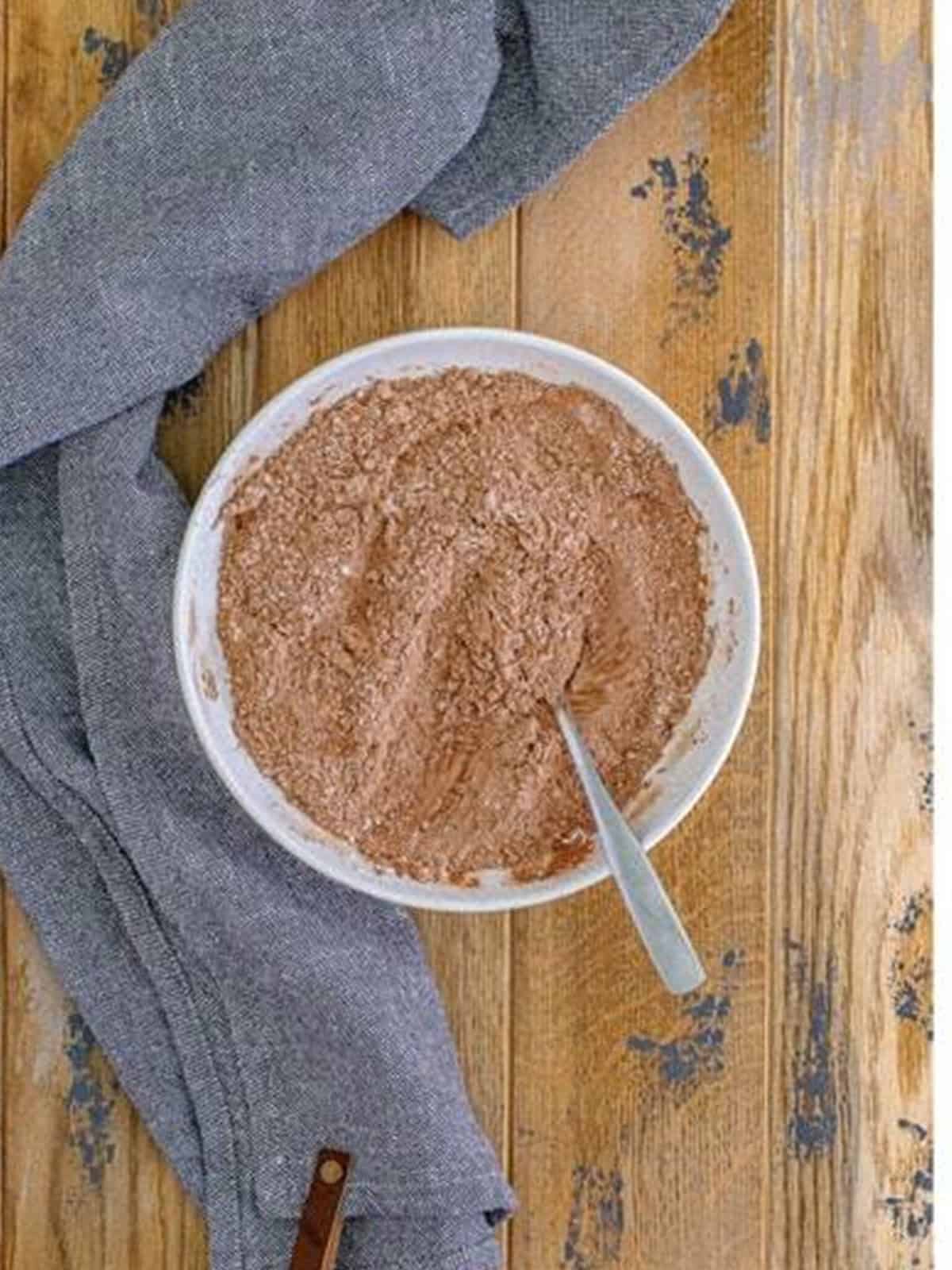Cocoa, flour, and dry ingredients stirred together in a bowl for mudslide cookies.