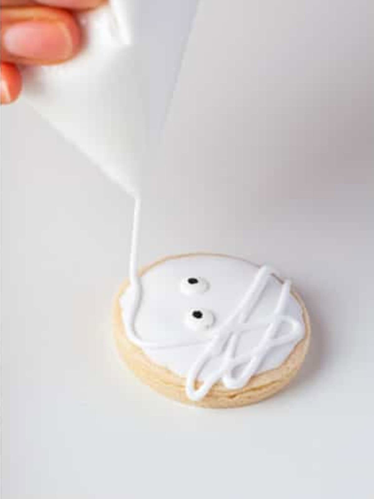 Royal icing drizzled in lines over a mummy cookie to look like mummy wrapping.