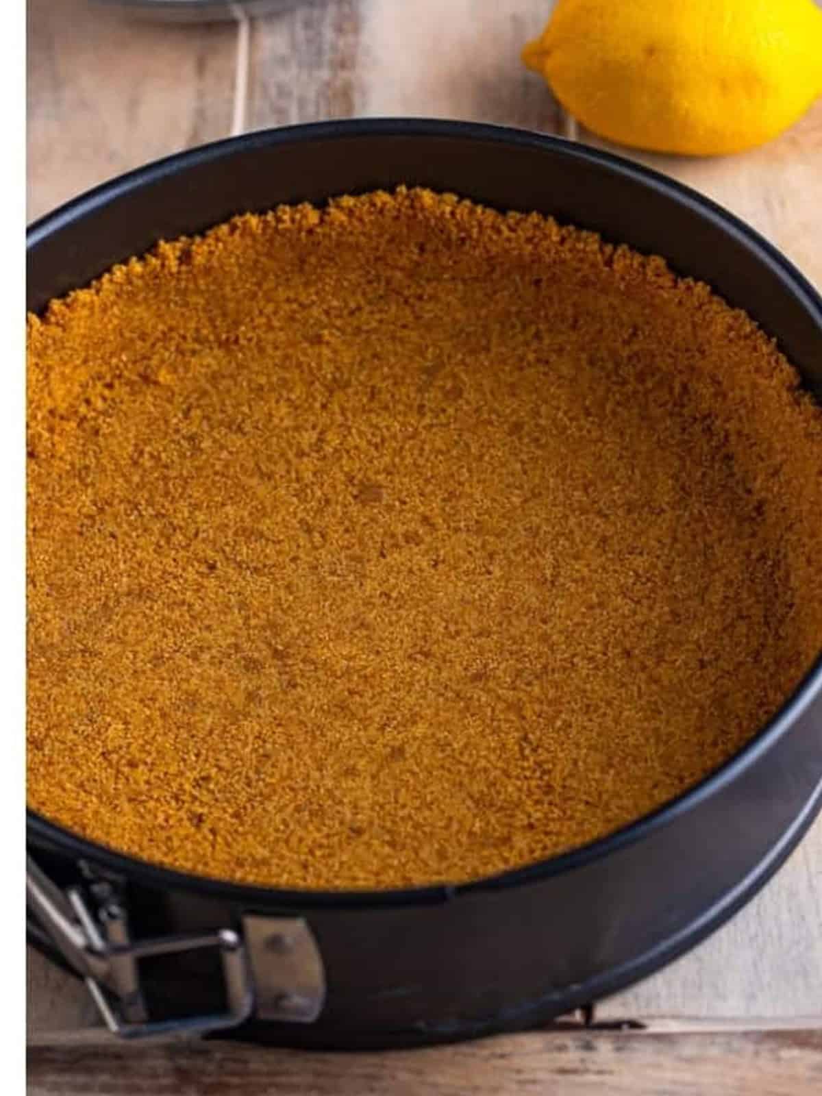 Graham cracker crust pressed evenly into a springform pan for No Bake Blueberry Cheesecake.