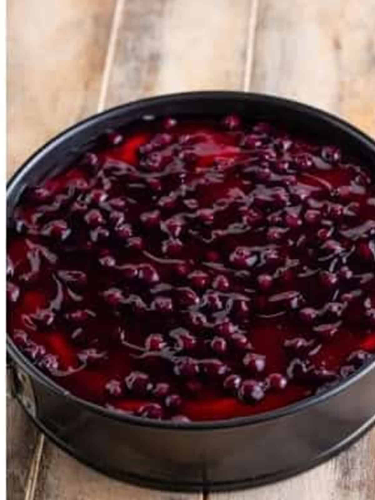 No Bake Blueberry Cheesecake topped with blueberry pie filling in the springform pan before chilling.