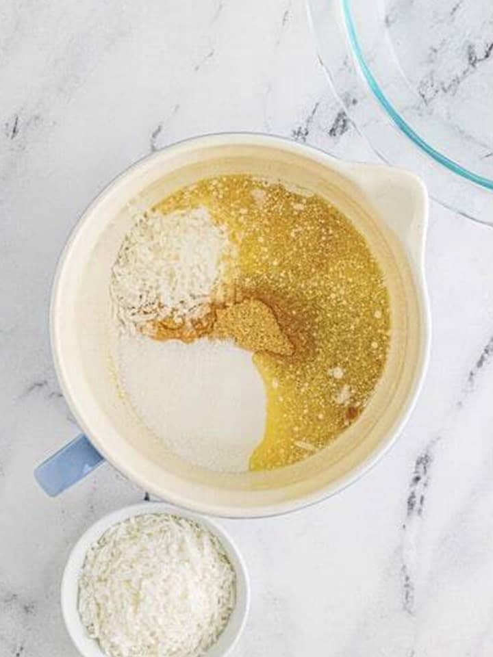 Graham cracker crumbs, coconut, sugar, and melted butter in a mixing bowl for the coconut cream pie crust.