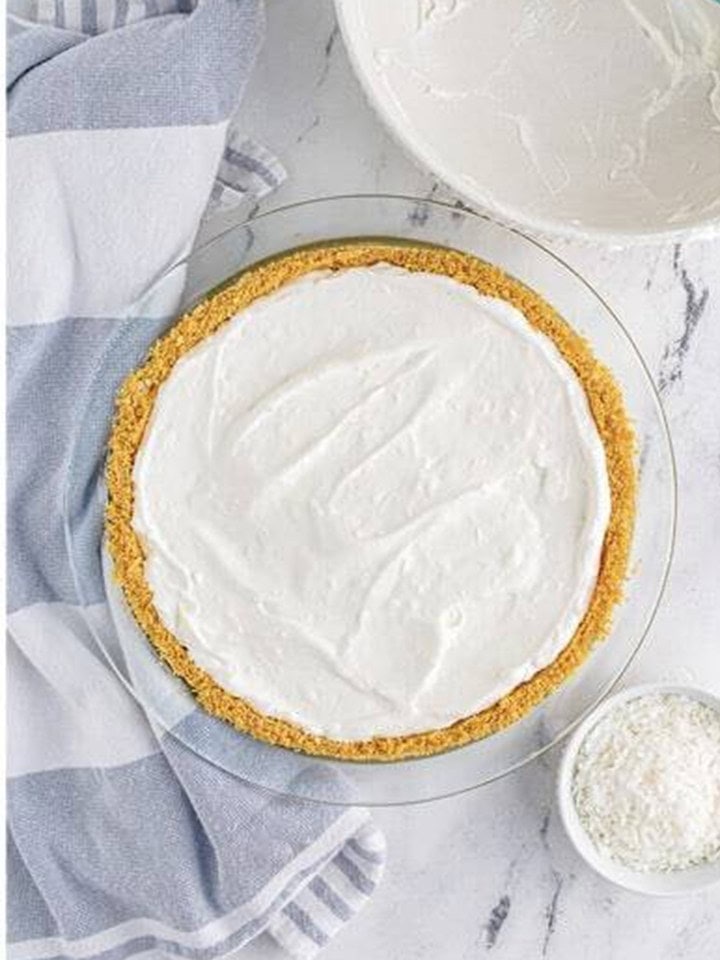 The coconut cream pie filling poured into the crust and smoothed before freezing.