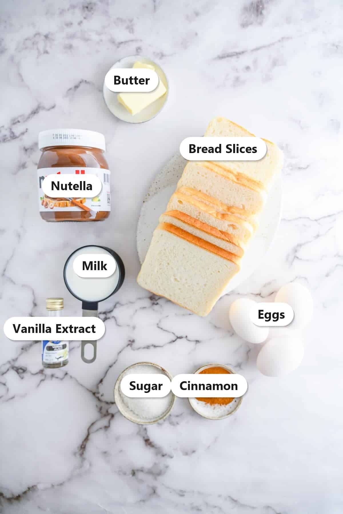 Labeled ingredients for stuffed Nutella French toast sticks including bread, Nutella, eggs, milk, and cinnamon sugar.