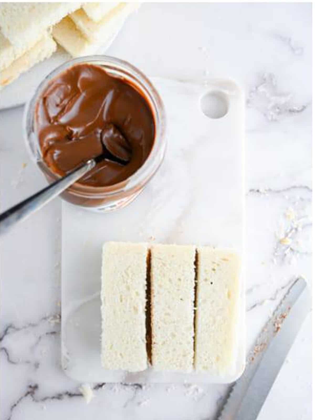 A Nutella sandwich sliced into thick sticks ready to be dipped in egg wash.