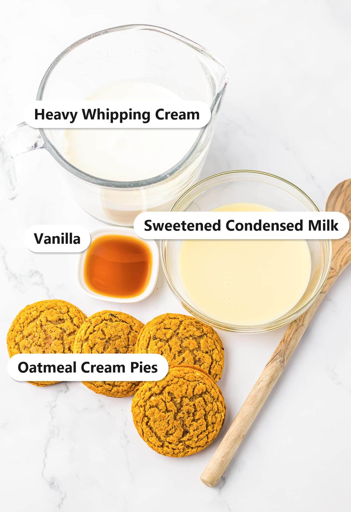 Labeled ingredients to make oatmeal cream pie ice cream bars including oatmeal cream pies, heavy whipping cream, sweetened condensed milk, and vanilla.