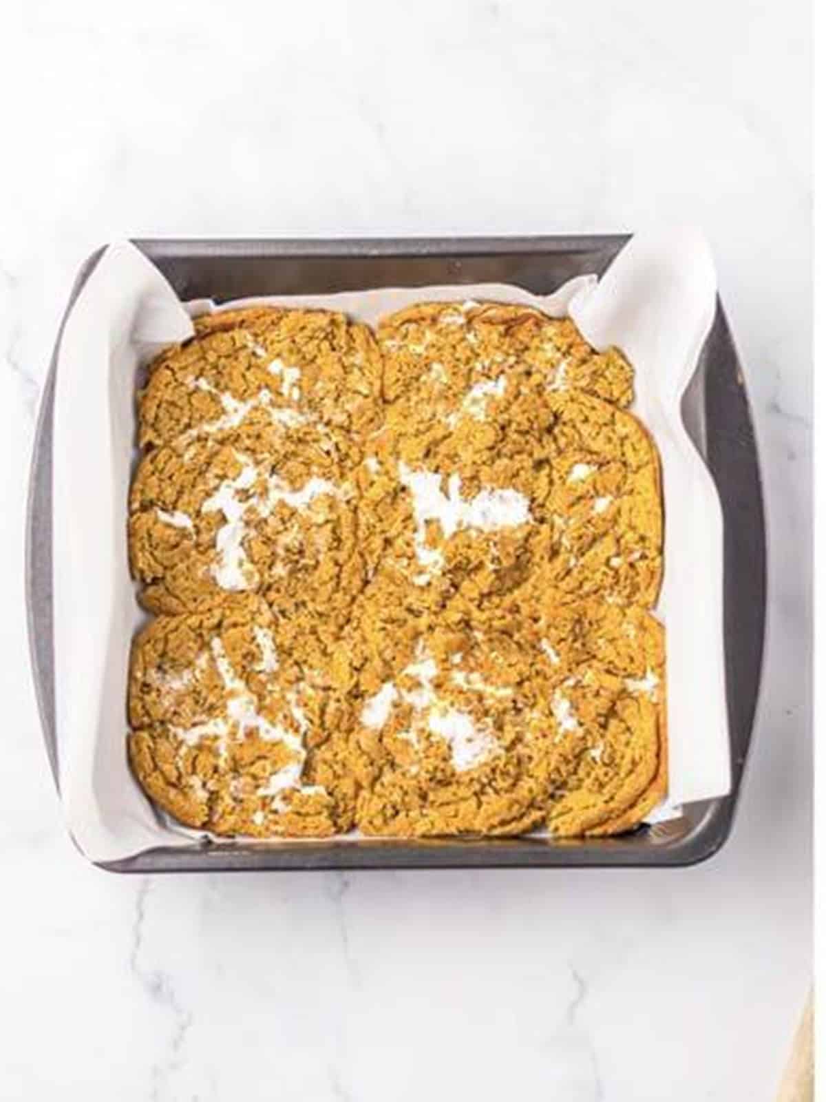 Oatmeal cream pies pressed into a parchment lined pan to form a crust.