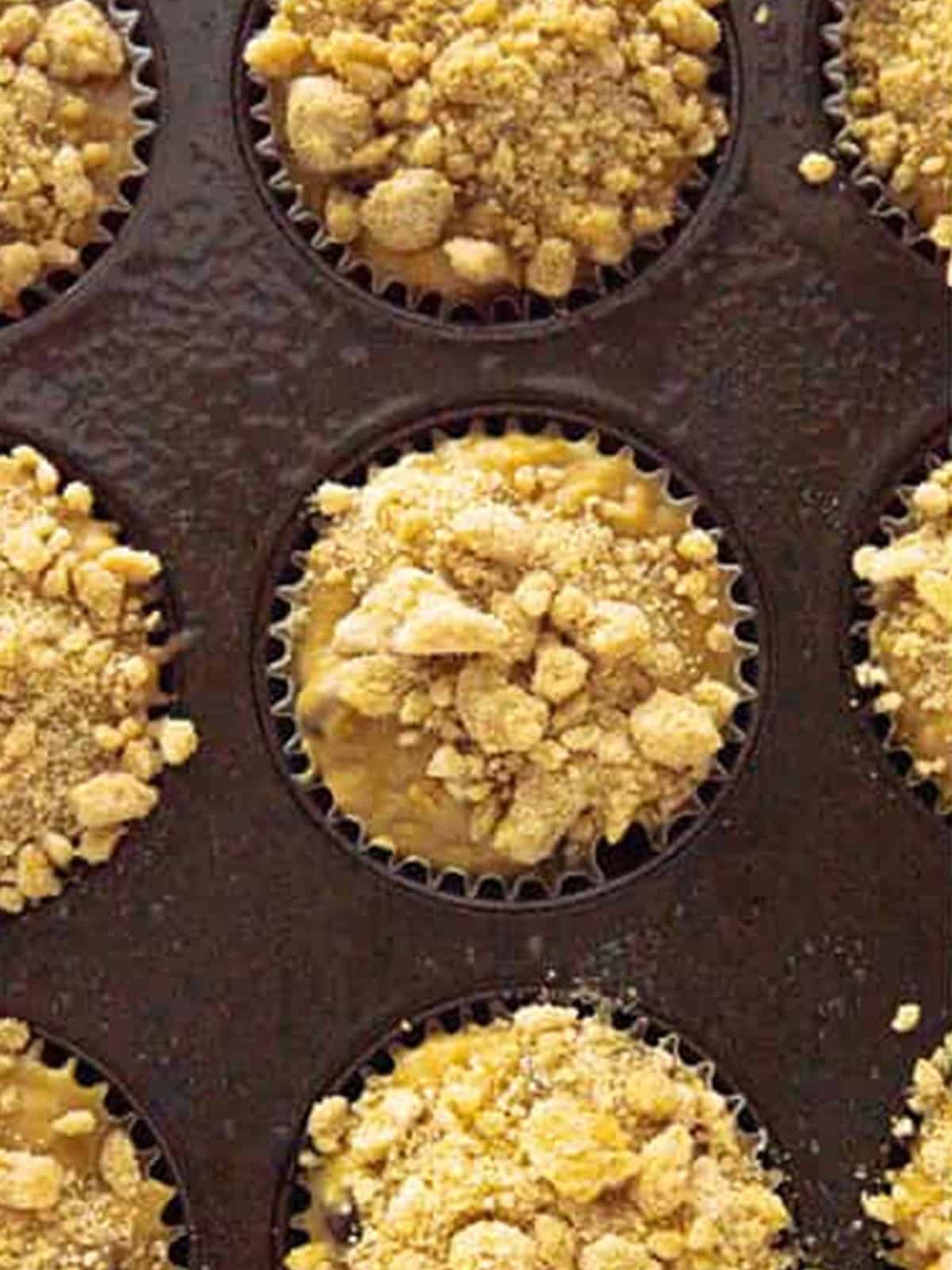 Baked oatmeal muffins topped with streusel in a muffin tin.