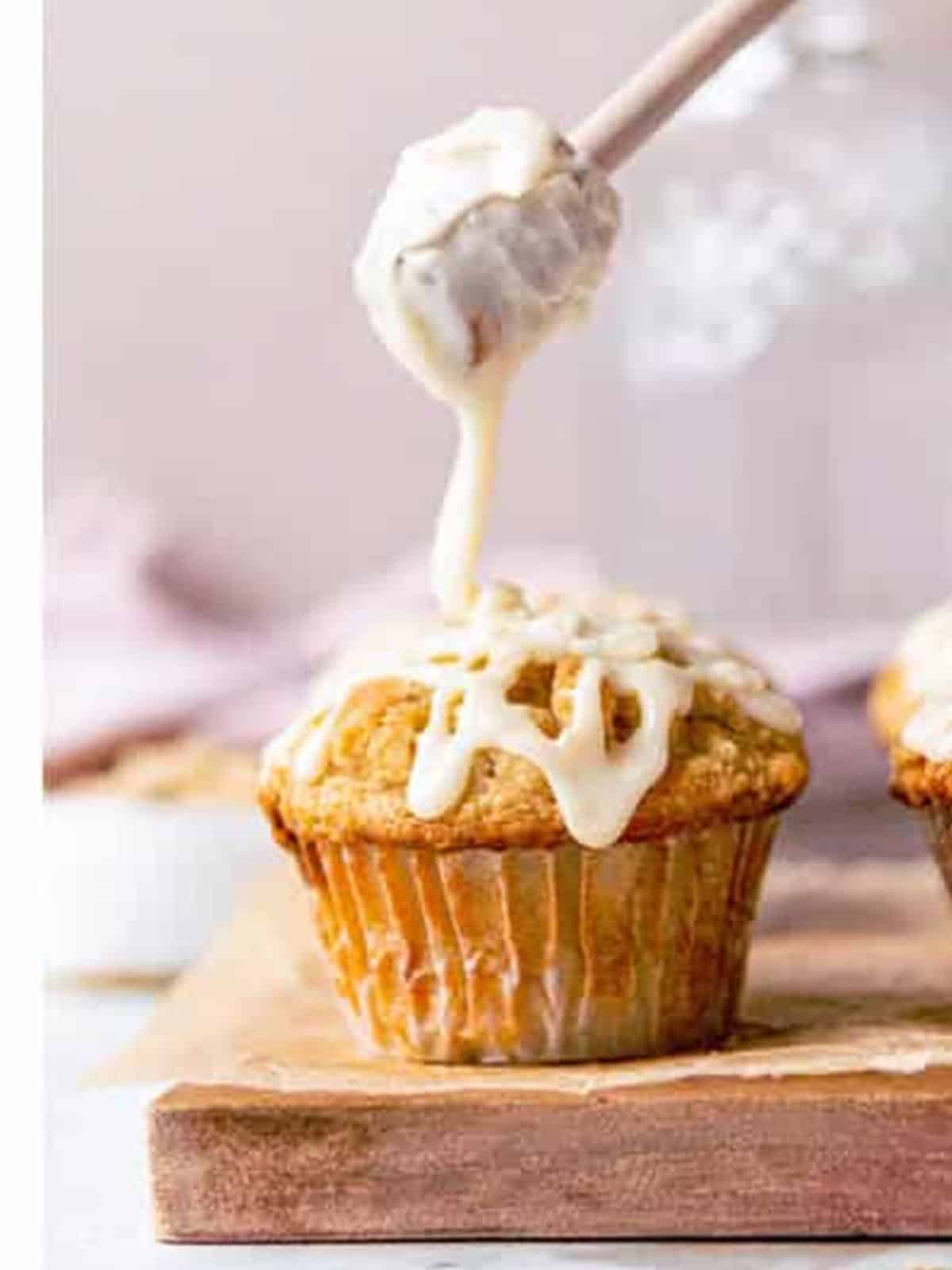 A chocolate chip oatmeal muffin being drizzled with maple glaze.