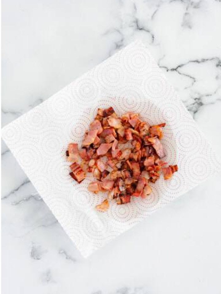 Crispy diced bacon draining on a paper towel for the Onion Tart topping.
