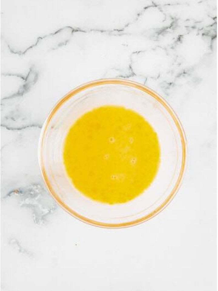 Egg whisked with water in a glass bowl for the pastry egg wash.