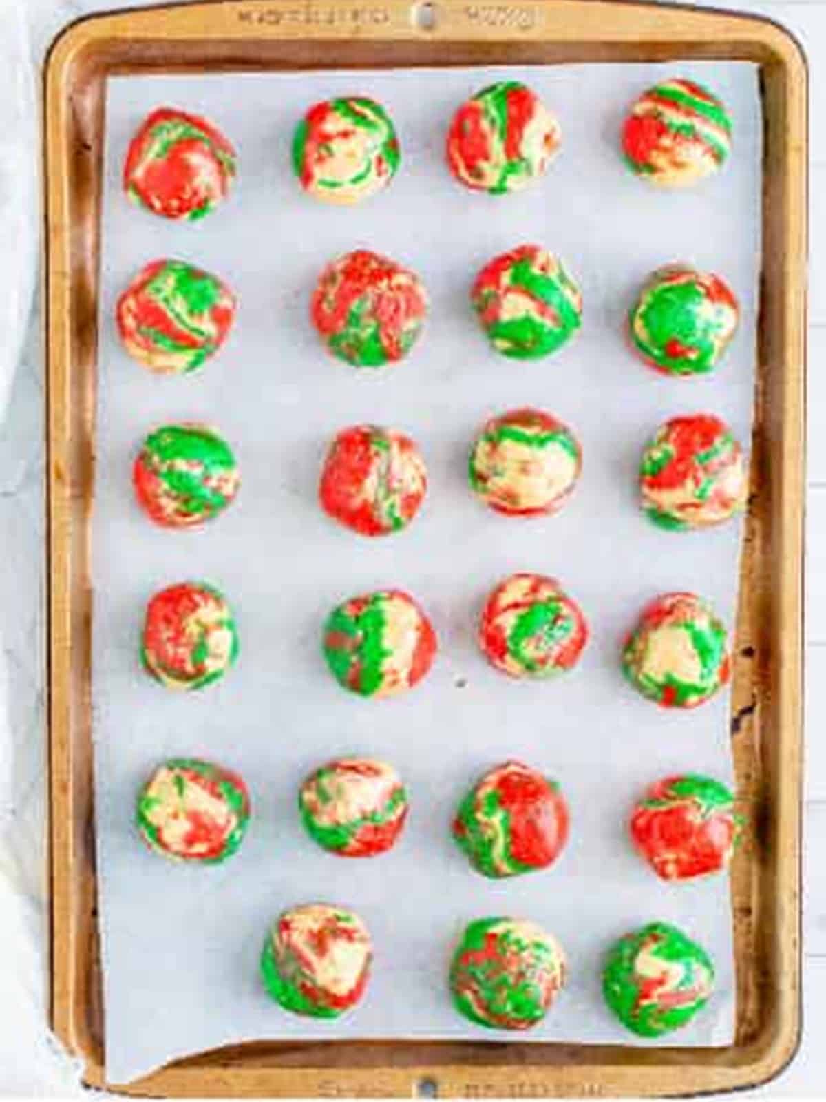 Rolled Oreo Balls on a parchment lined sheet tray before freezing.