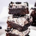 A stack of Oreo Brownies showing the fudgy brownie base and thick Oreo cream cheese fudge layer on top.