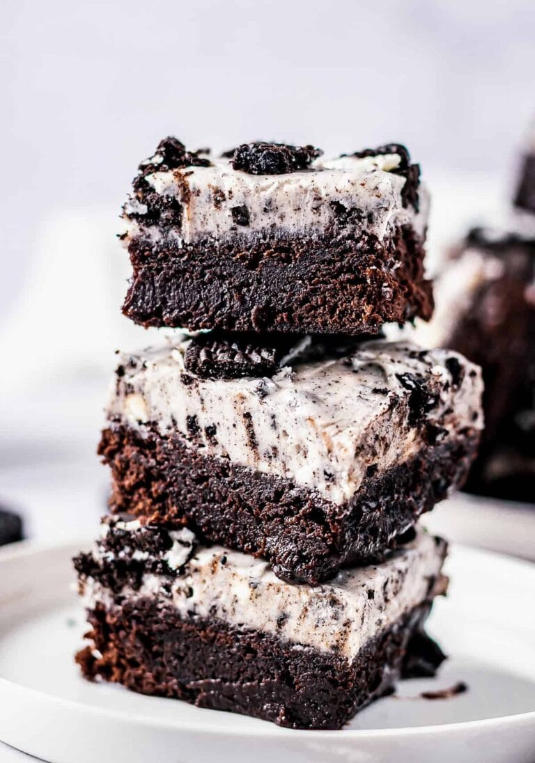A stack of Oreo Brownies showing the fudgy brownie base and thick Oreo cream cheese fudge layer on top.