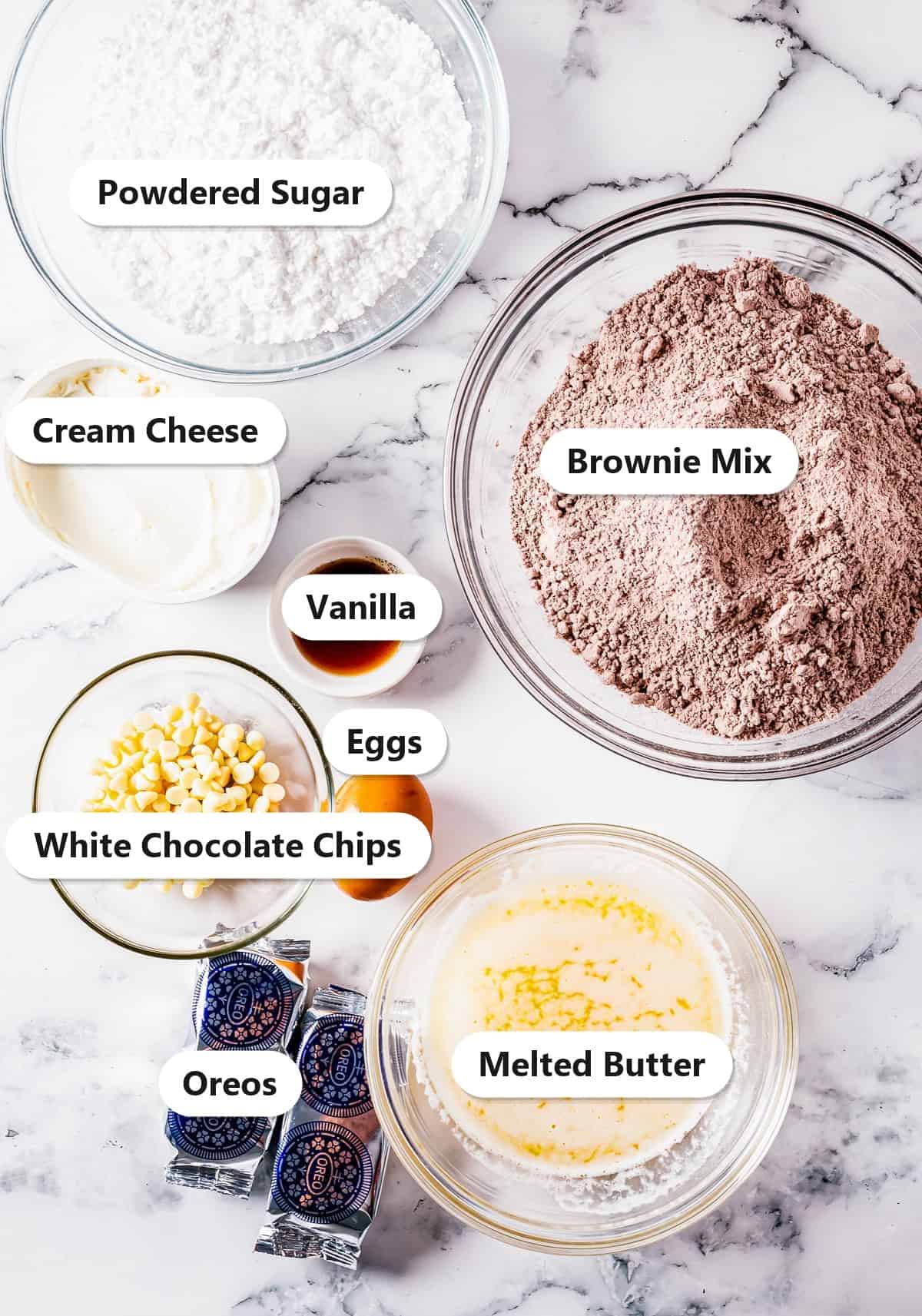 Labeled ingredients for Oreo Brownies including fudge brownie mix, cream cheese, powdered sugar, white chocolate chips, and Oreos.