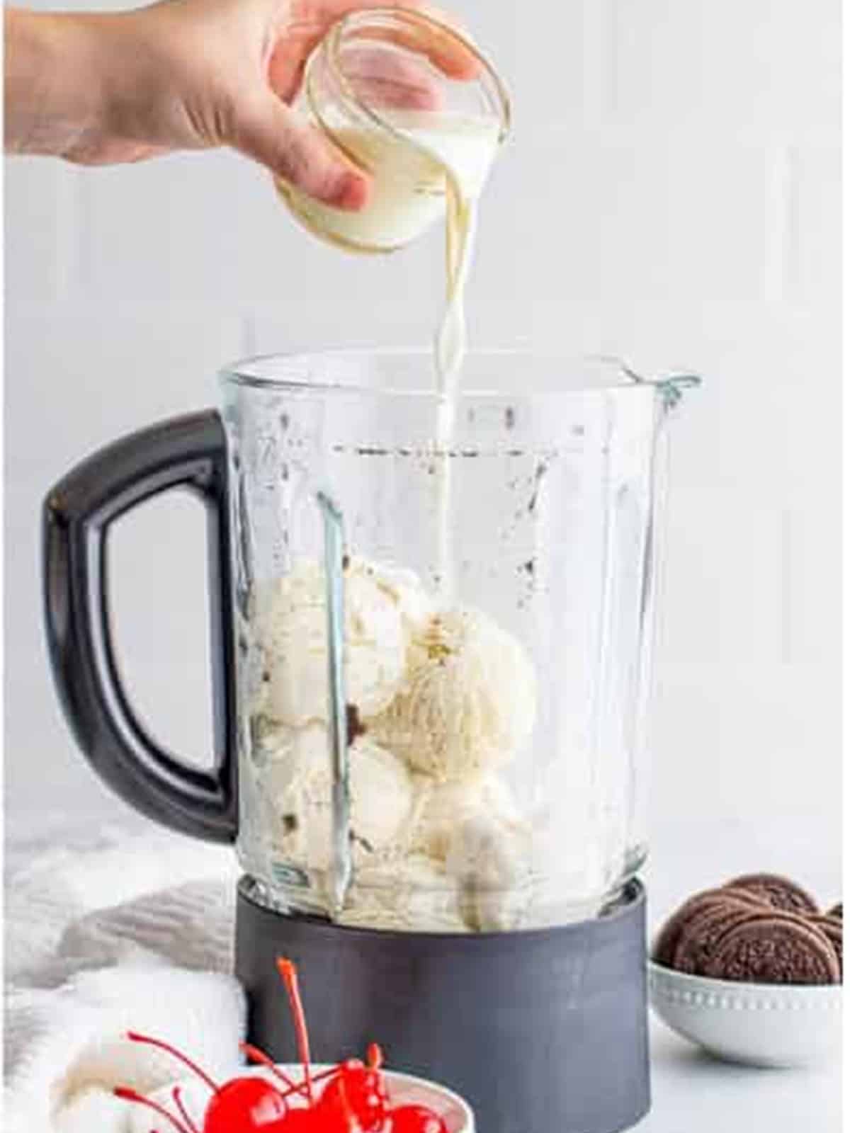 Whole milk poured into the blender with the ice cream and cookies.