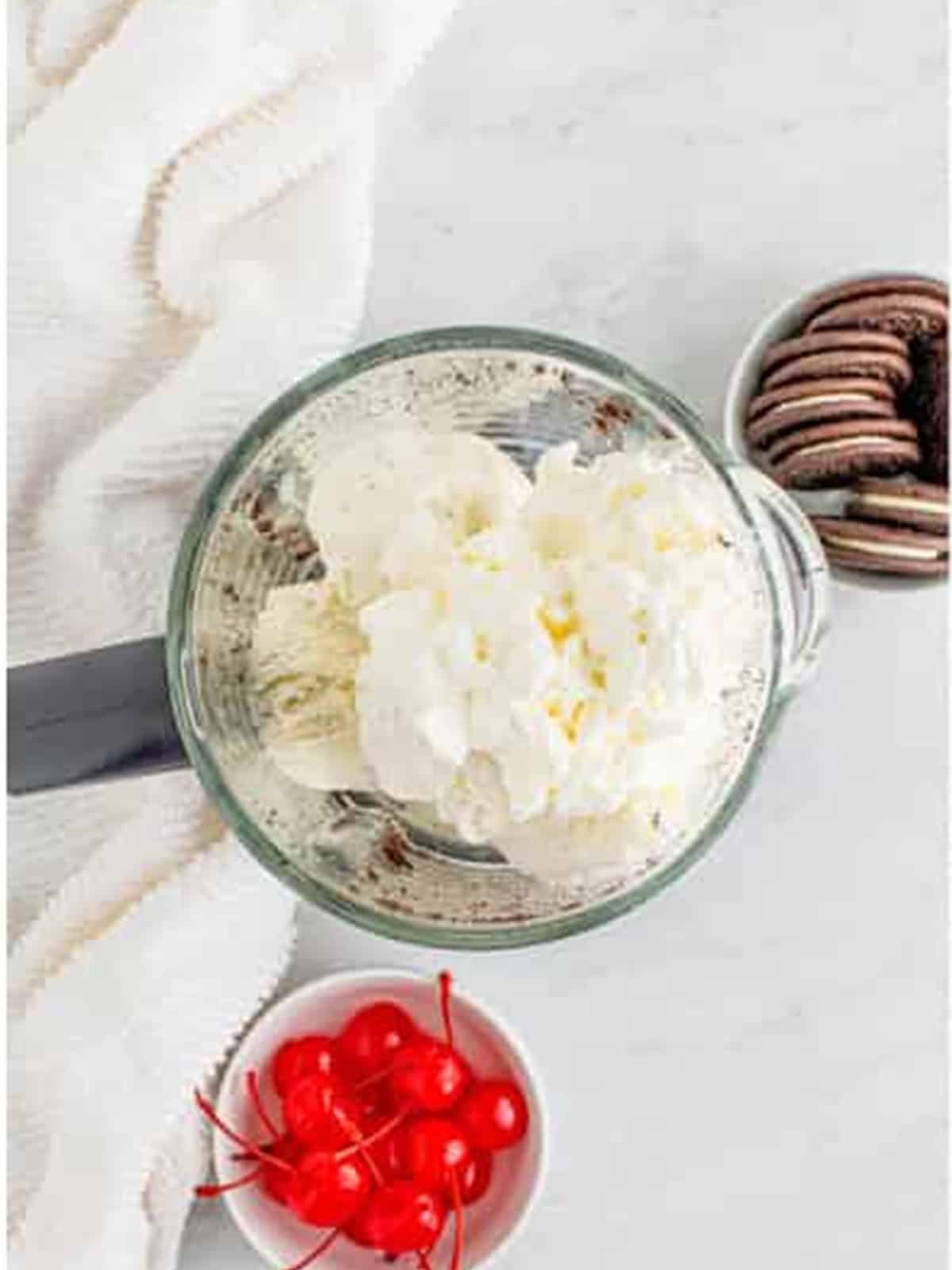 Whipped cream added to the blender before blending the milkshake.