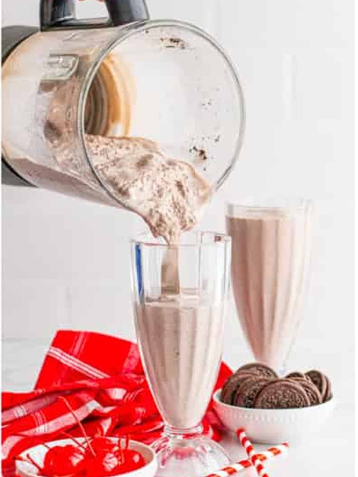 Pouring the thick Oreo Milkshake into two milkshake glasses.