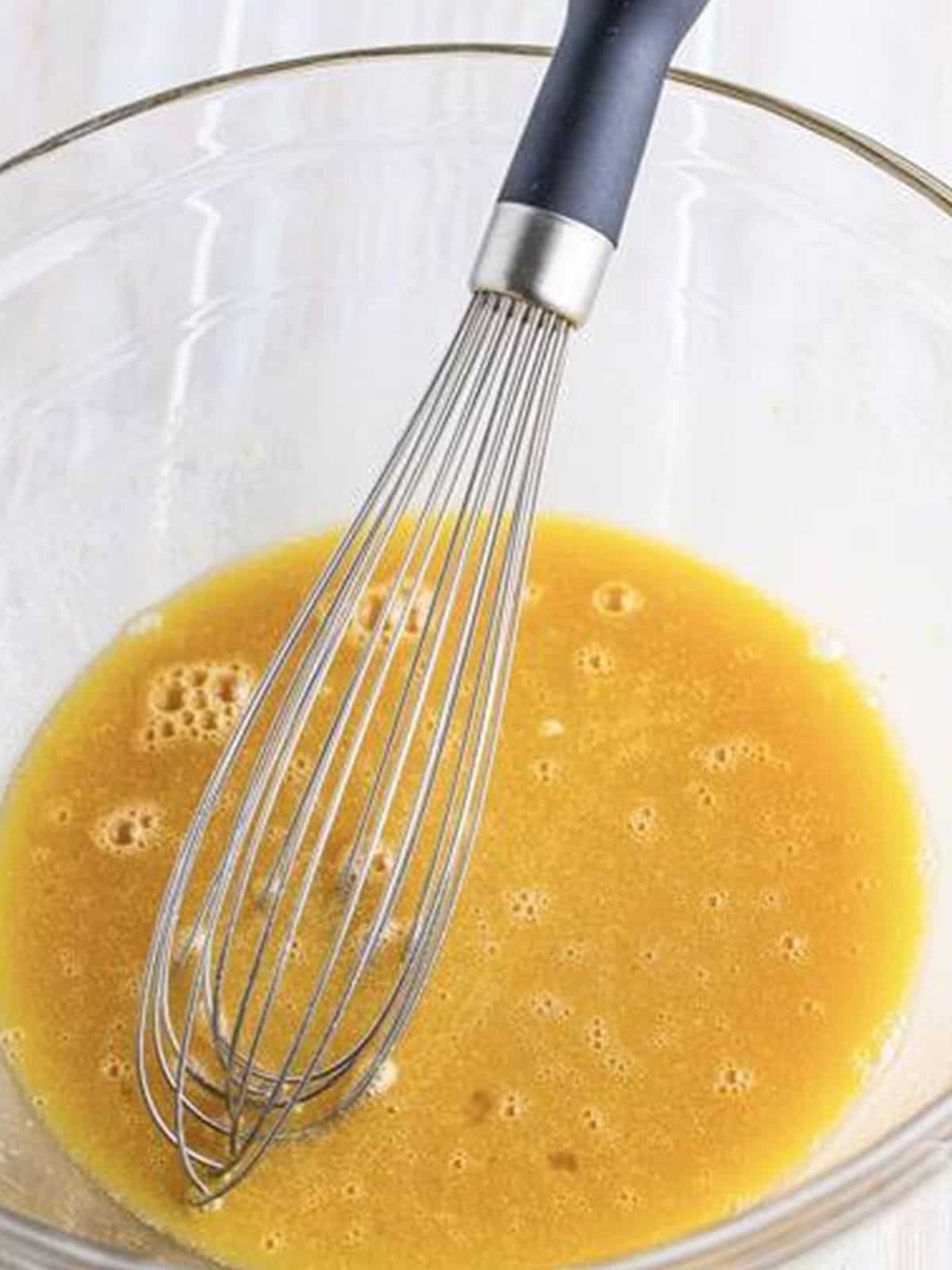 Milk, sugar, maple syrup, oil, egg, and vanilla whisked together for pancake cupcakes.