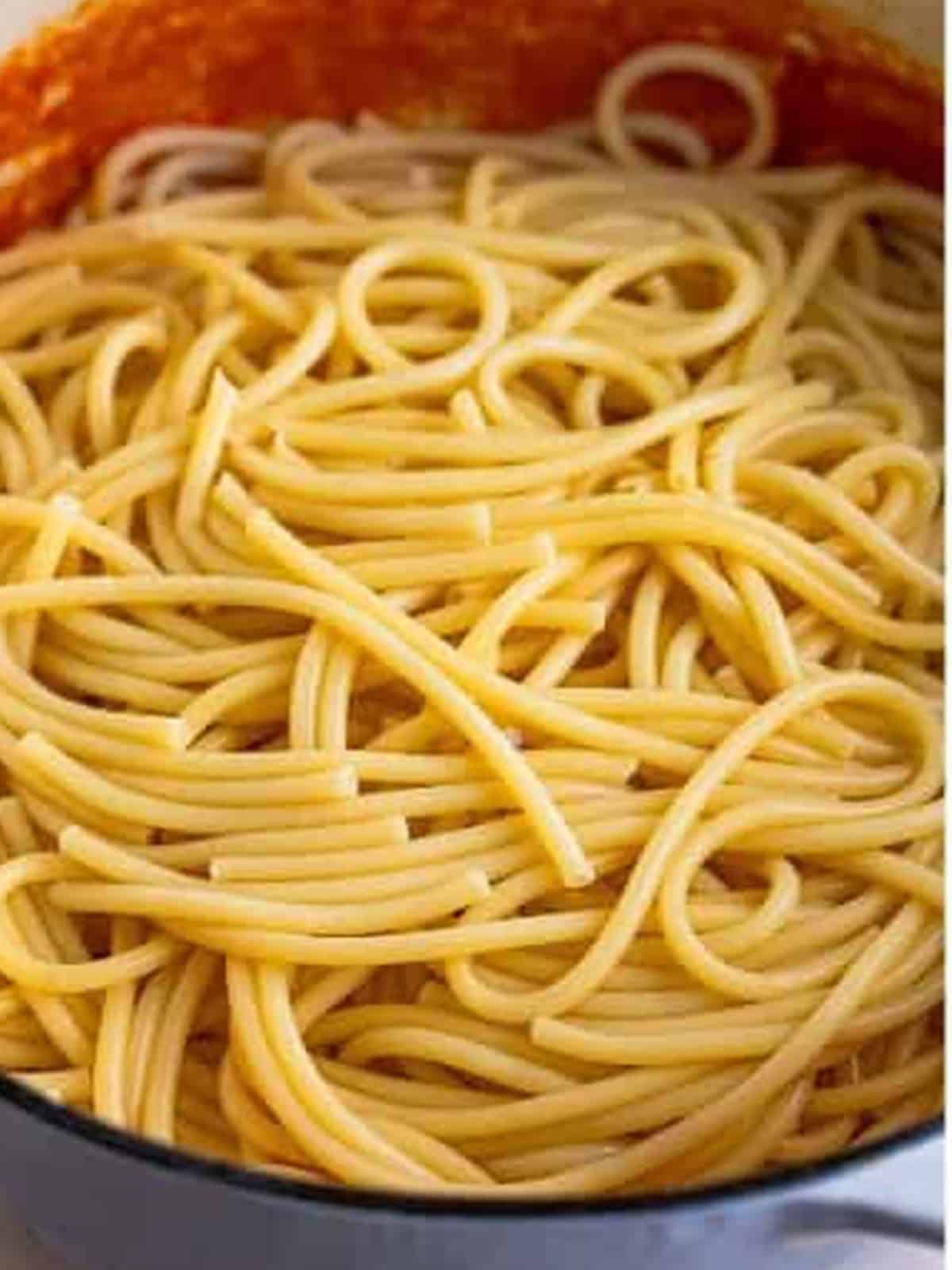 Bucatini cooked to al dente in a pot of water for Pasta Amatriciana.