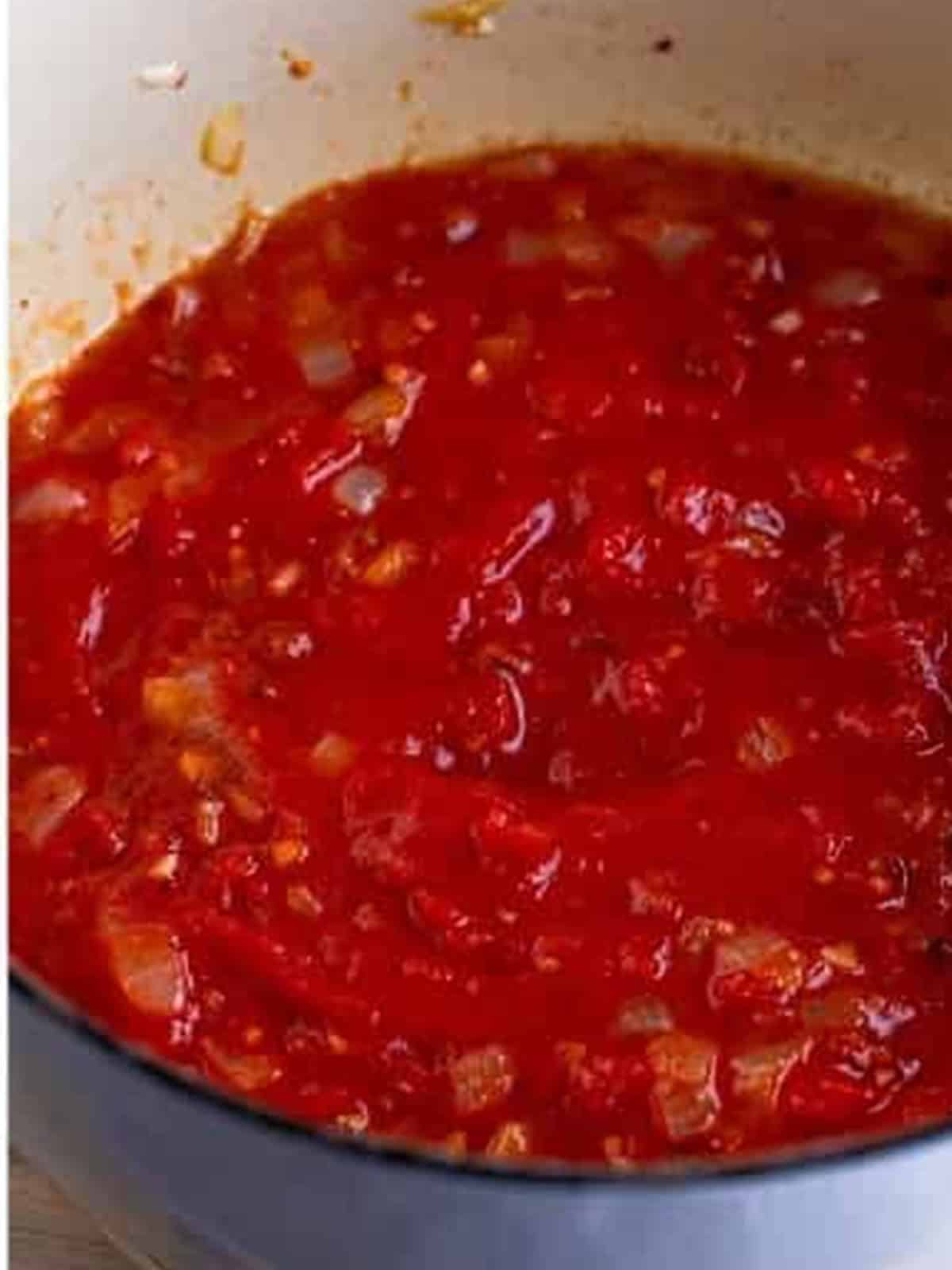 Hand crushed San Marzano tomatoes simmering into a thick sauce for Pasta Amatriciana.