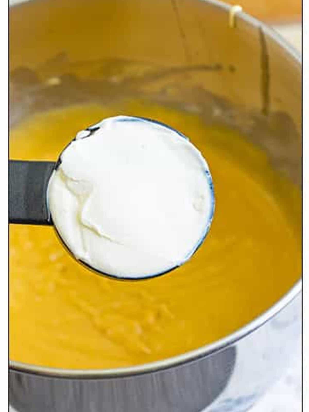 Scoop of sour cream added to the finished cake batter