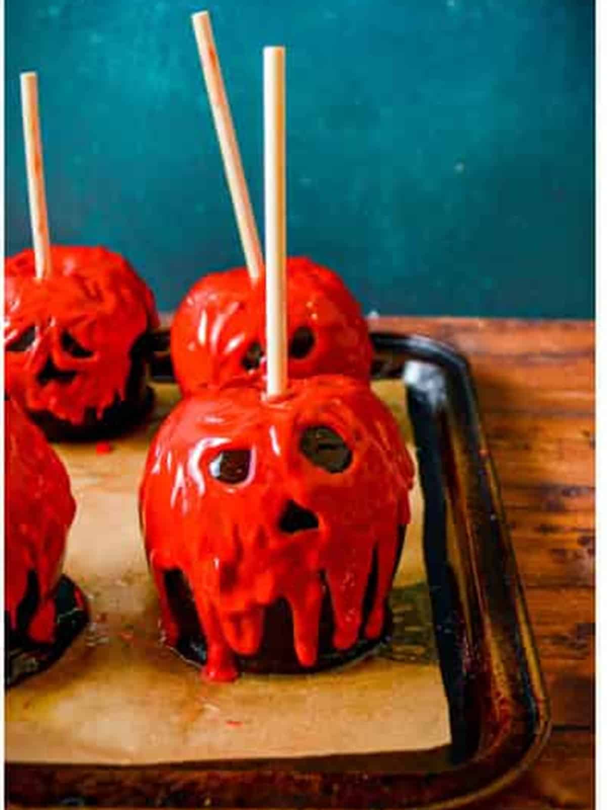 Red candy melts dripping down poison apples as the spooky faces harden.