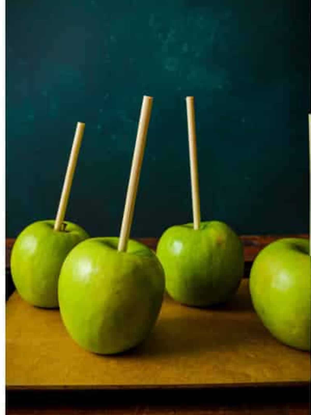 Green apples with wooden skewers pressed into the stem ends for poison apples.
